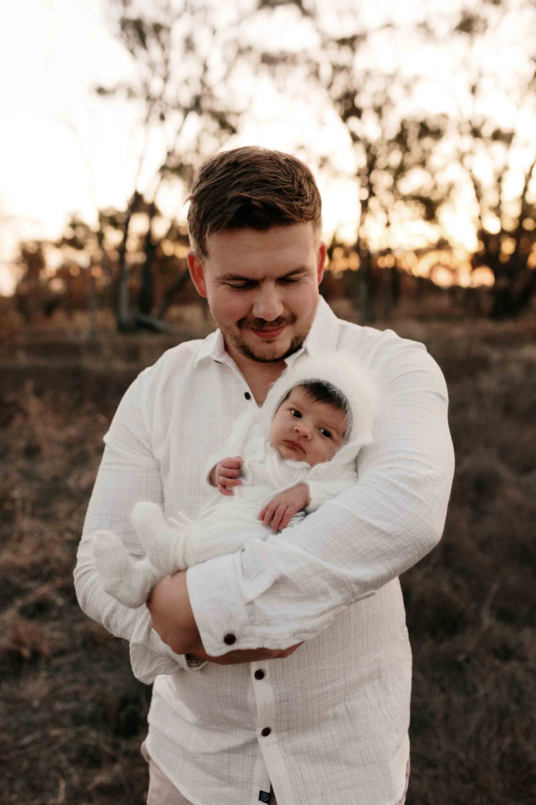 An Adelaide dad with their newborn baby at an outdoor photography session.