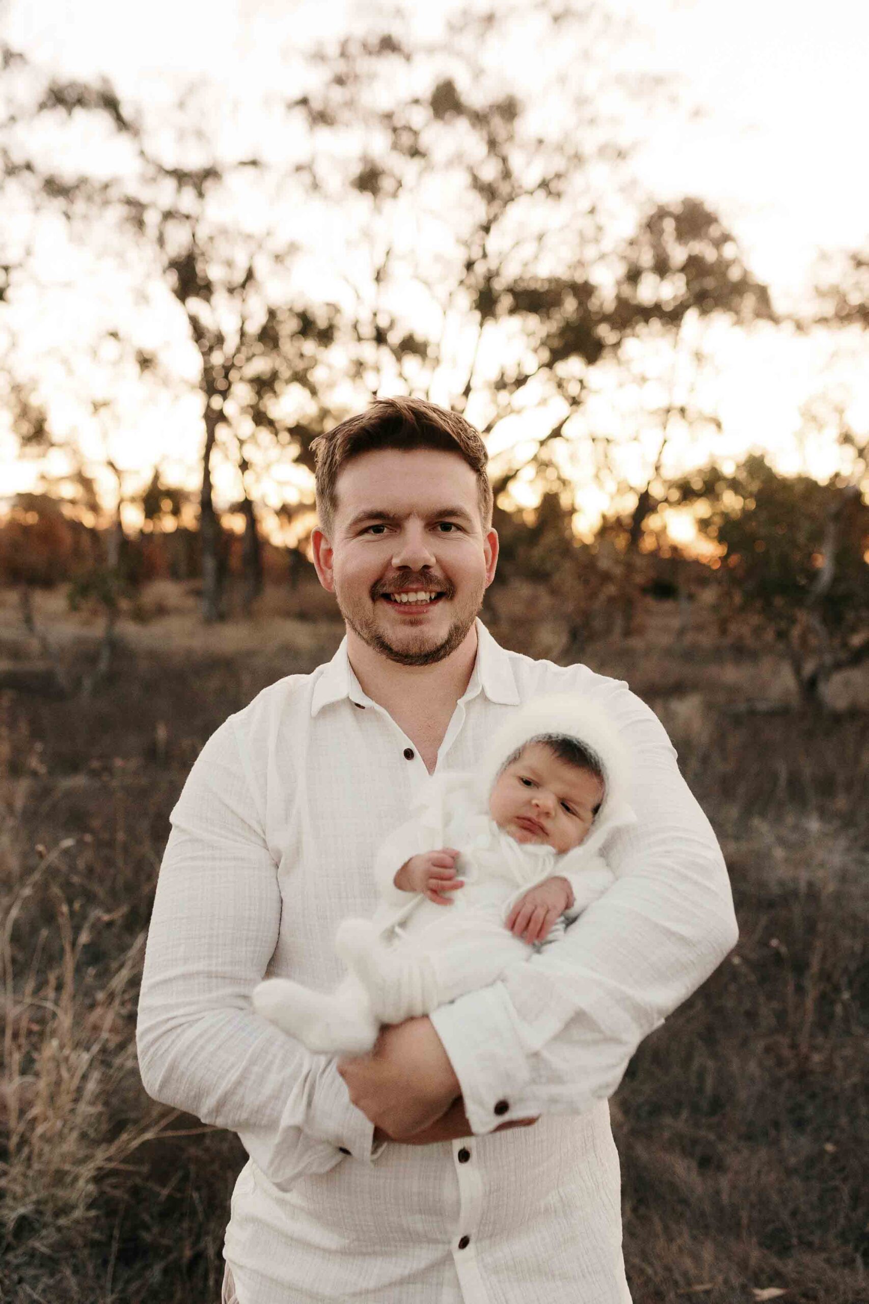 An Adelaide dad with their newborn baby at an outdoor photography session.