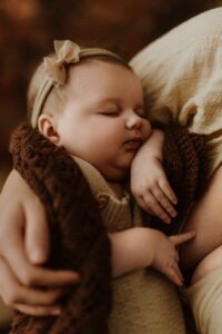 A mum cuddling with her 12 week old baby girl in an Adelaide newborn studio.