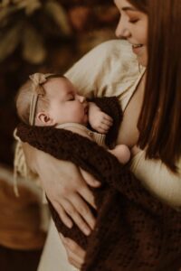 A mum cuddling with her 12 week old baby girl in an Adelaide newborn studio.