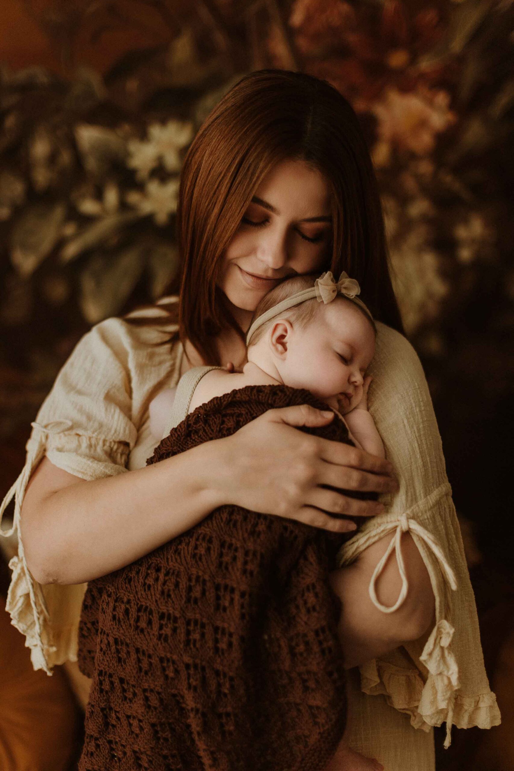 A mum cuddling with her 12 week old baby girl in an Adelaide newborn studio.