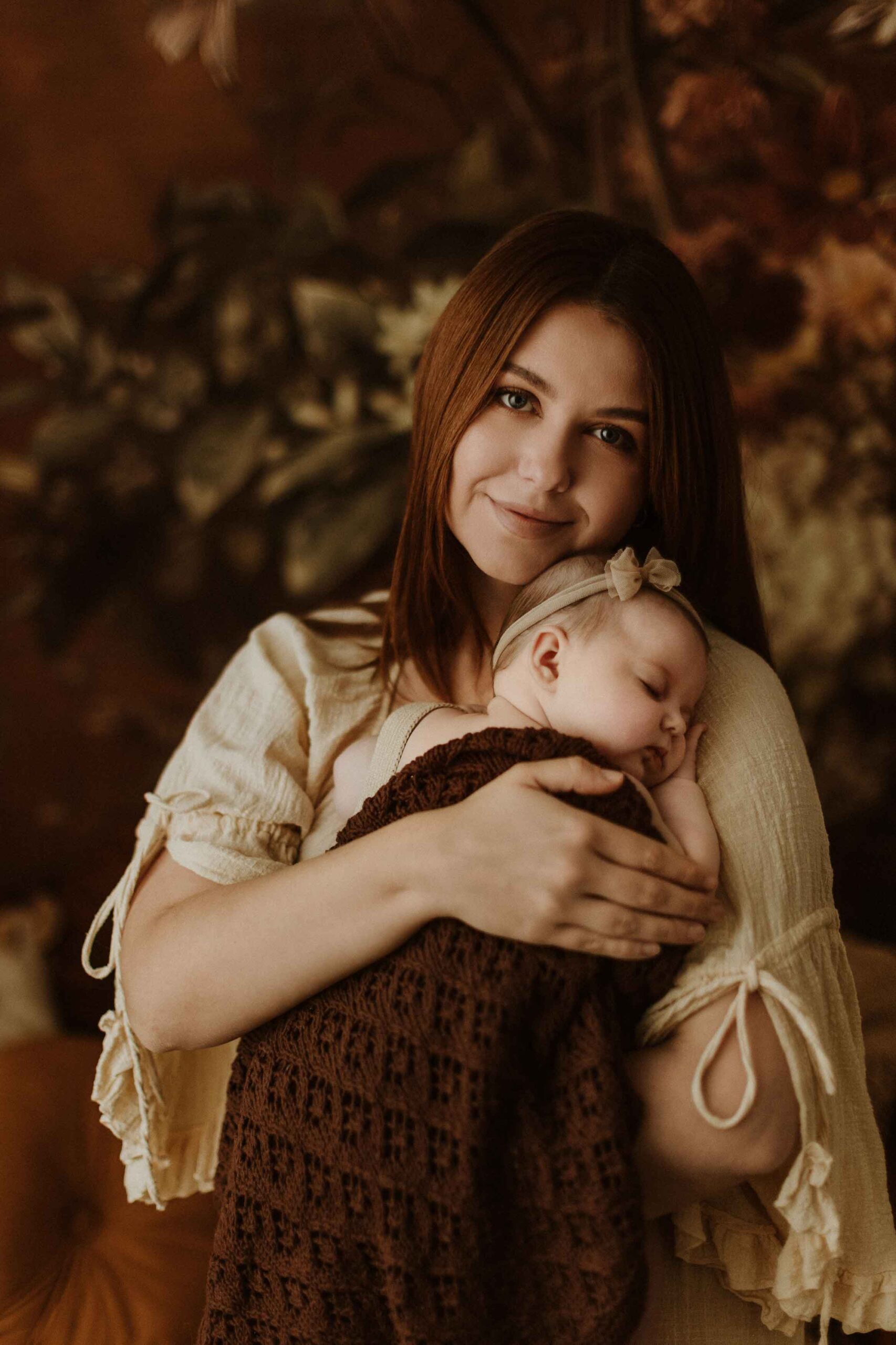 A mum cuddling with her 12 week old baby girl in an Adelaide newborn studio.