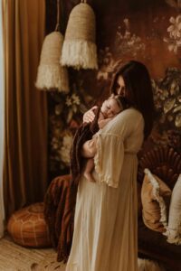 A mum cuddling with her 12 week old baby girl in an Adelaide newborn studio.