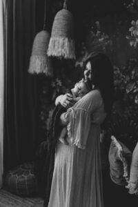 A mum cuddling with her 12 week old baby girl in an Adelaide newborn studio.