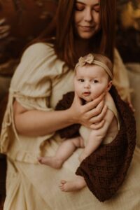 An Adeliade mum holding up her 12 week old baby and giving her a burp.
