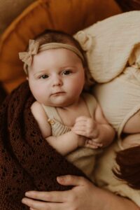A mum holding her 12 week old baby girl in an Adelaide newborn studio.