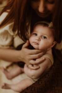 An Adeliade mum holding up her 12 week old baby and giving her a burp.