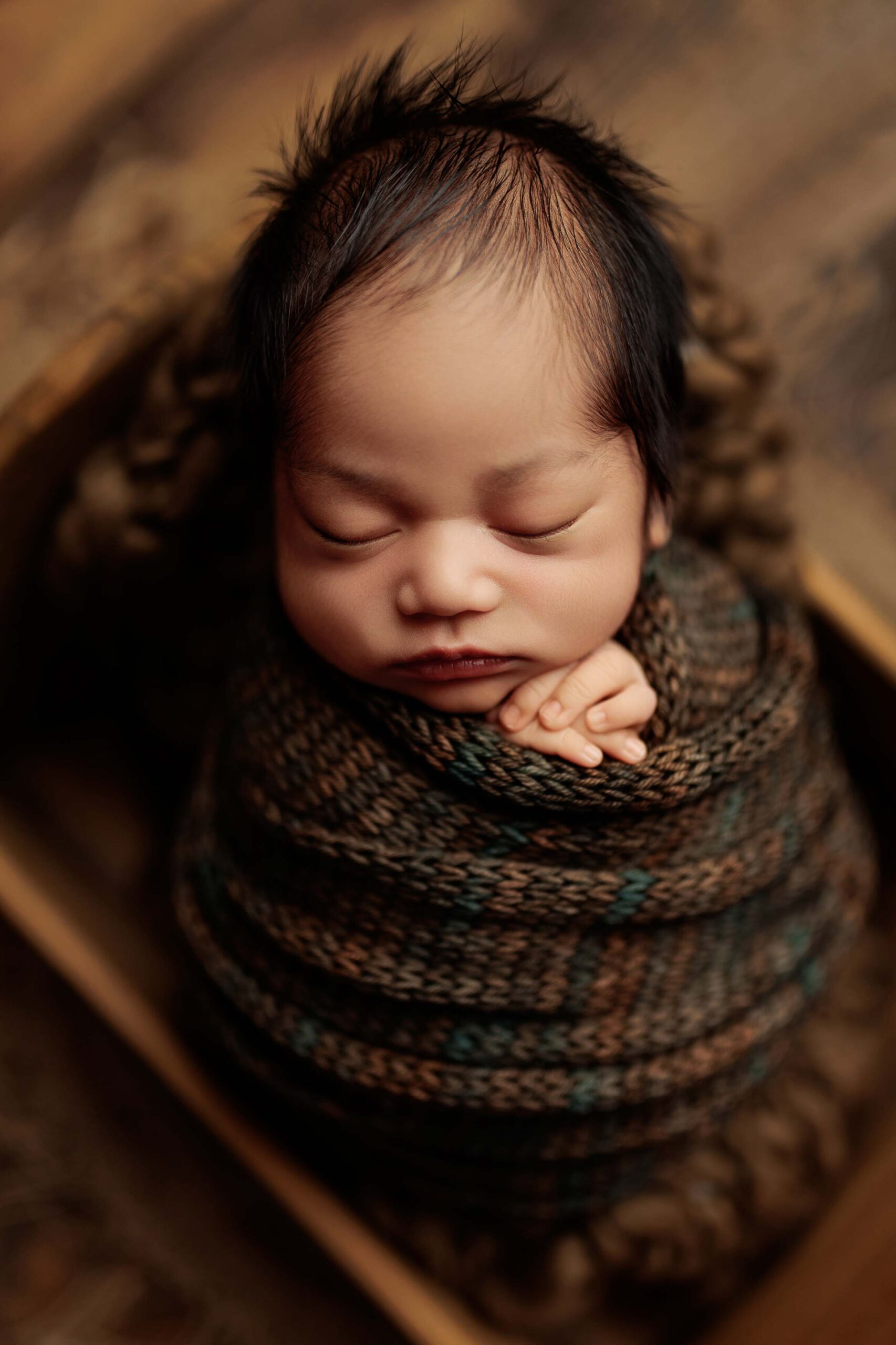 An Adelaide baby wrapped and asleep in a crate.