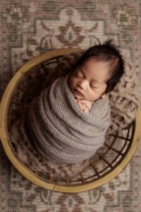 An Adelaide baby wrapped and asleep in a bowl.