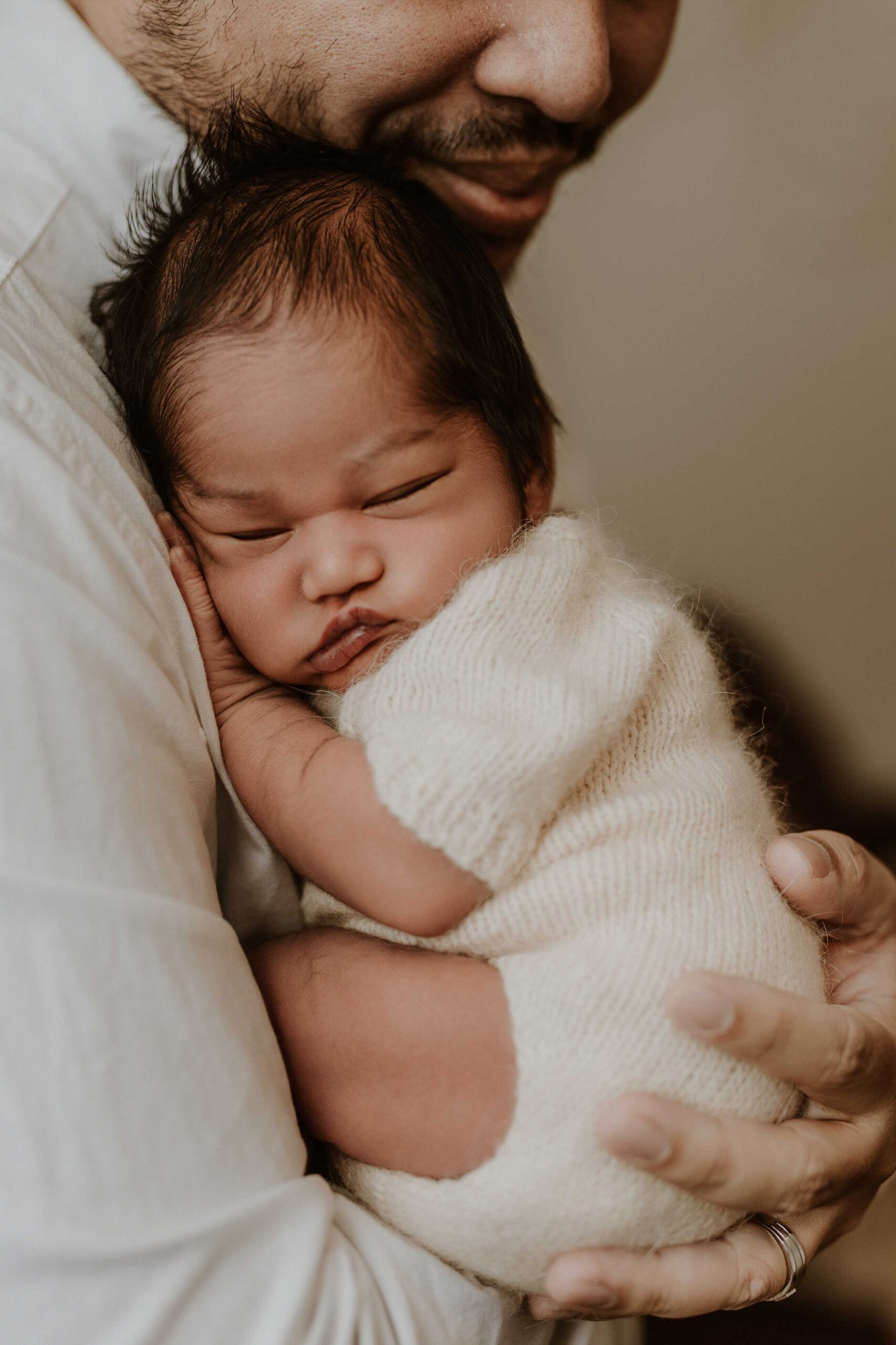 A closeup of an Adelaide dad holding his baby.