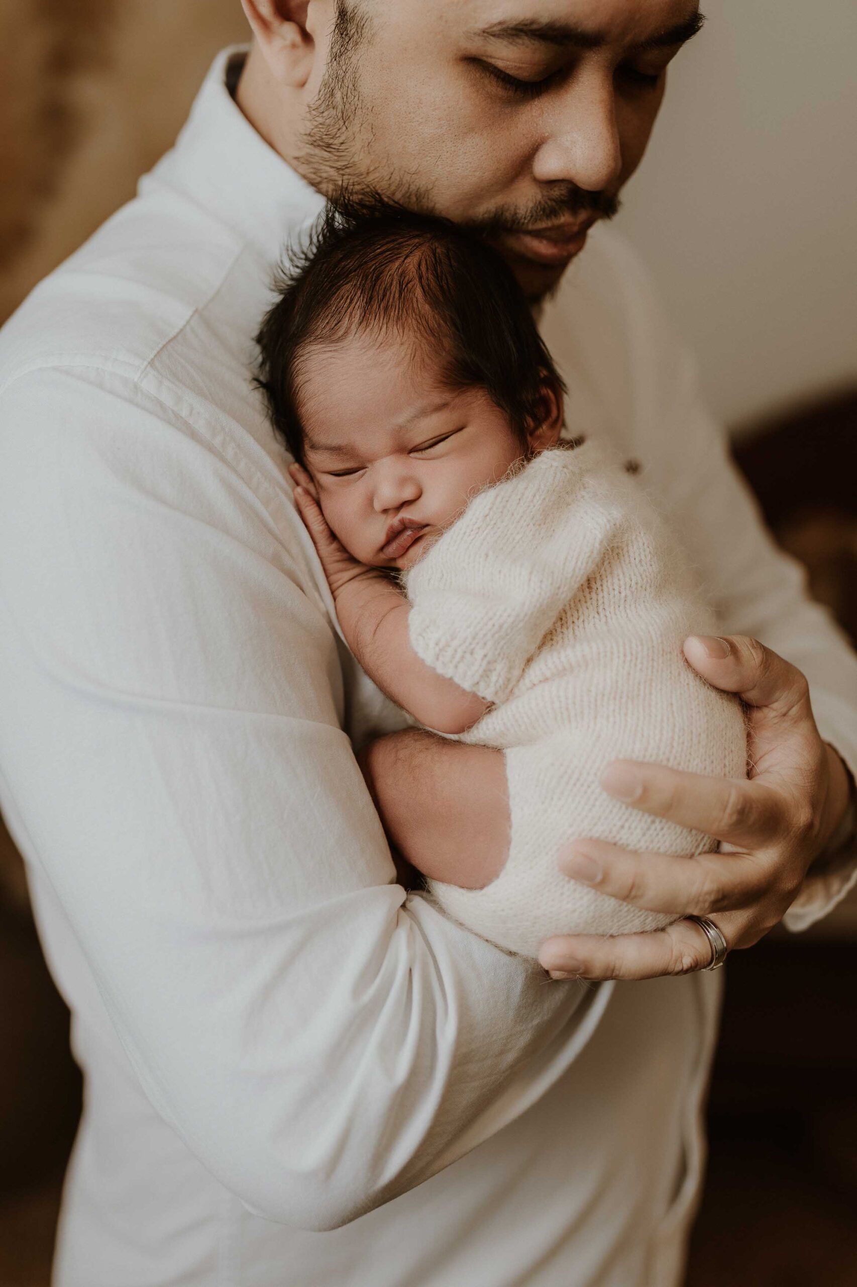 A closeup of an Adelaide dad holding his baby.