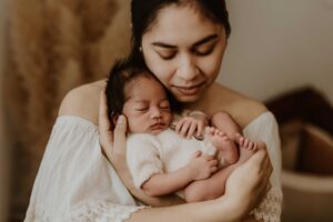 A close up of an Adelaide mum holding her newborn baby on her chest.