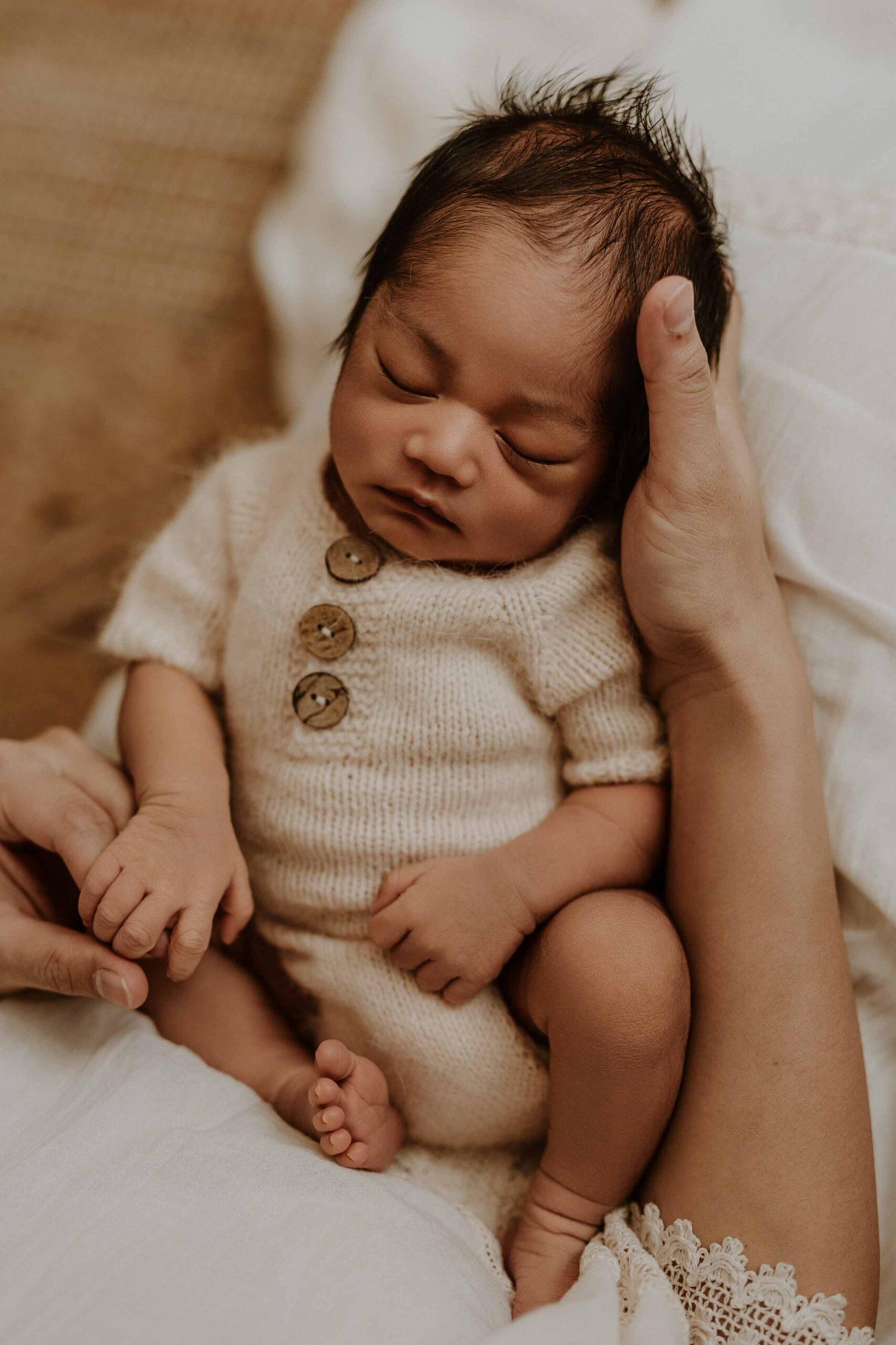 A closeup of an Adelaide newborn baby sitting in his Adelaide mums lap.