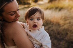 An Adelaide baby looking at the camera while in his mothers arms.