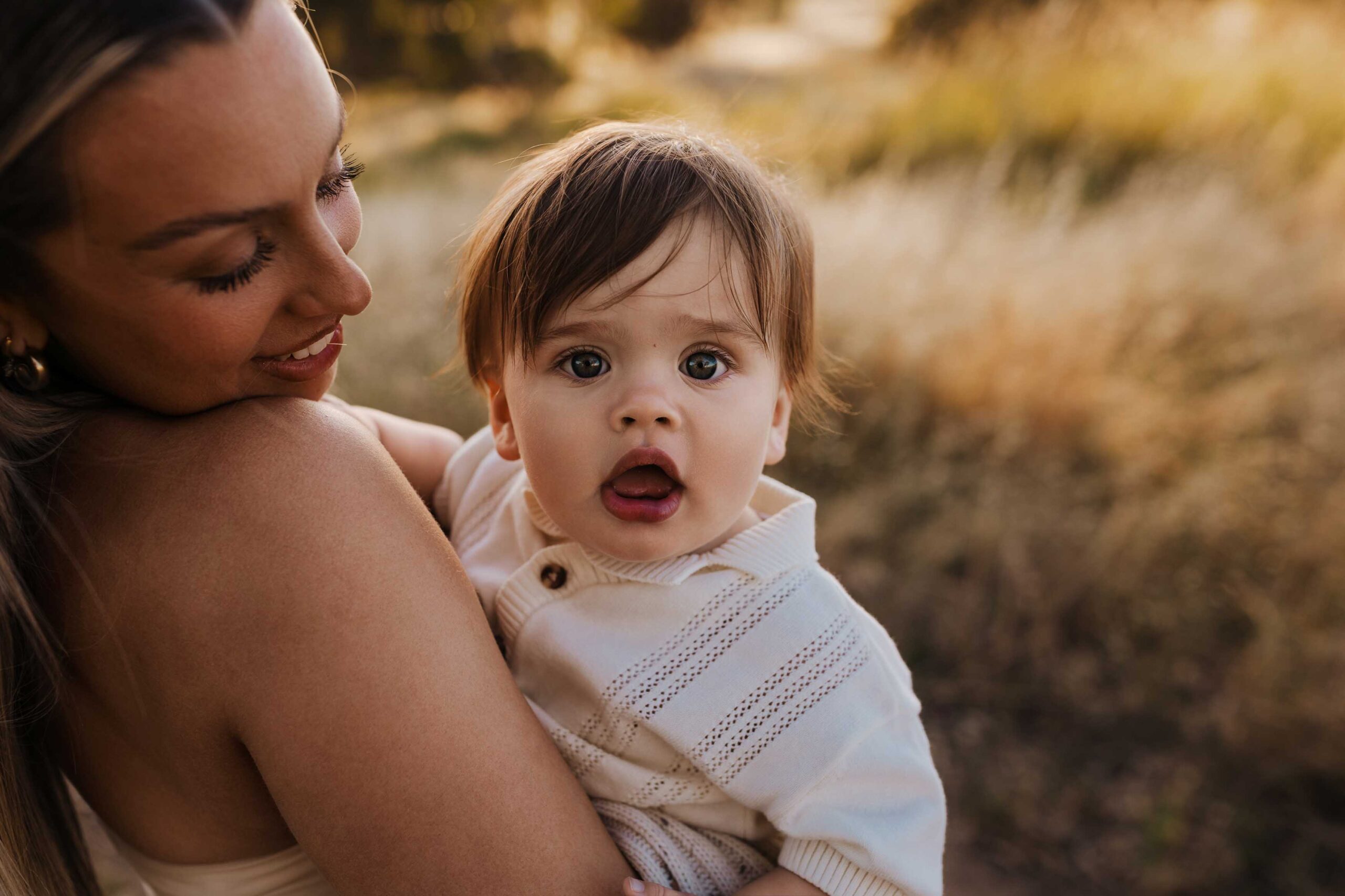 An Adelaide baby looking at the camera while in his mothers arms.