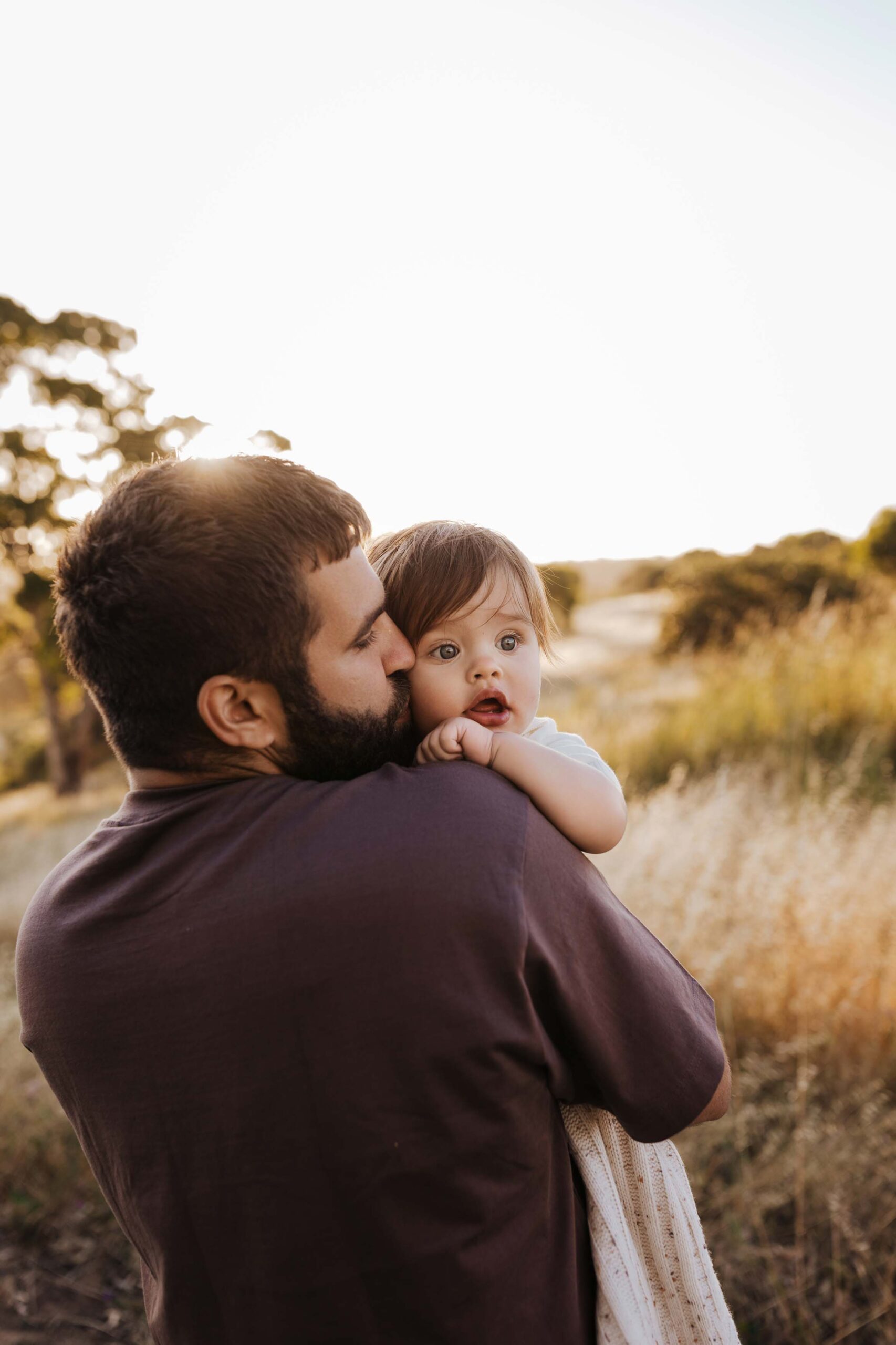 A dad from Adelaide kissing his baby son on the cheek.