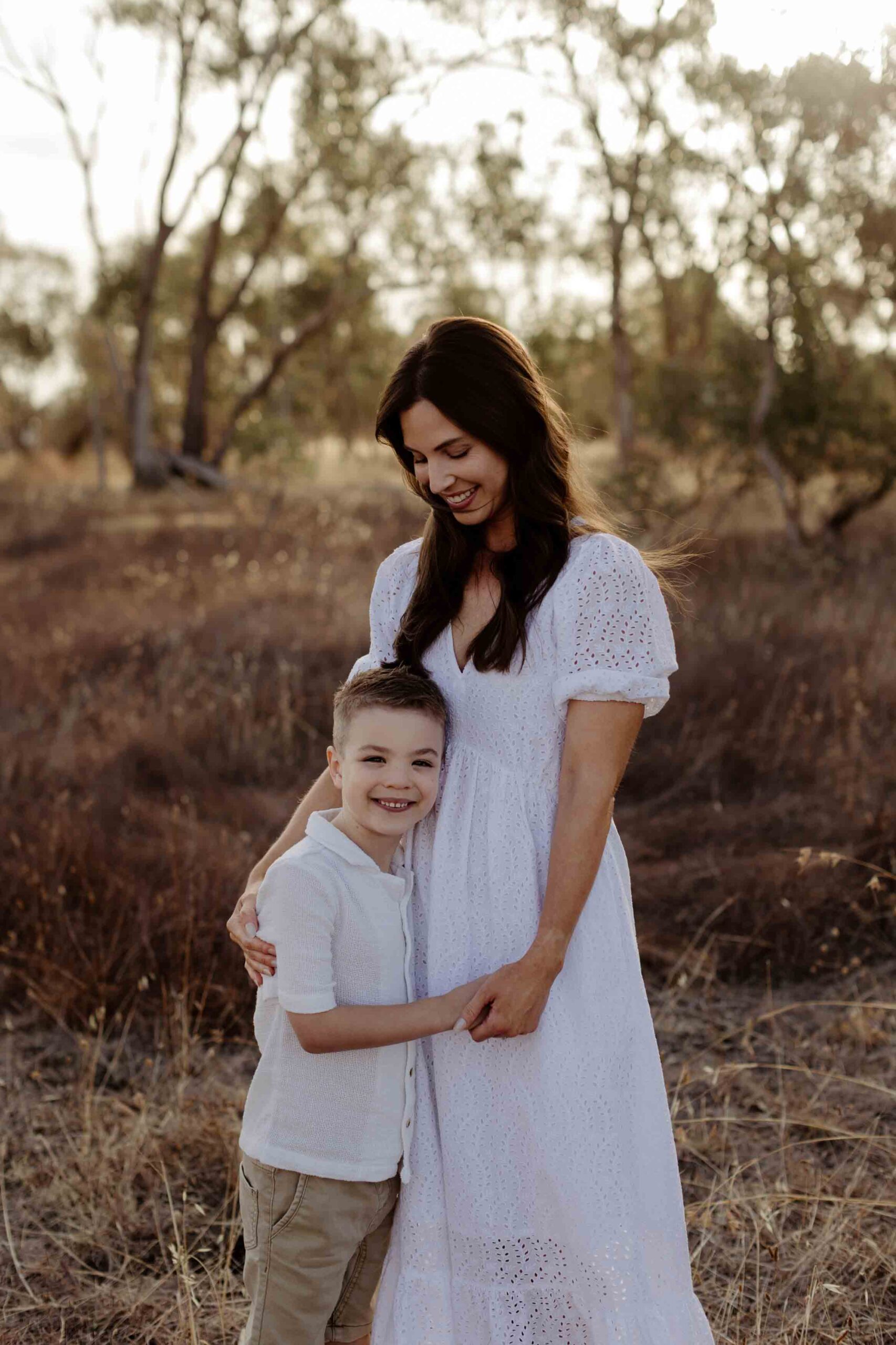 Natural outdoor family photography in Adelaide with parents and young child hugging.
