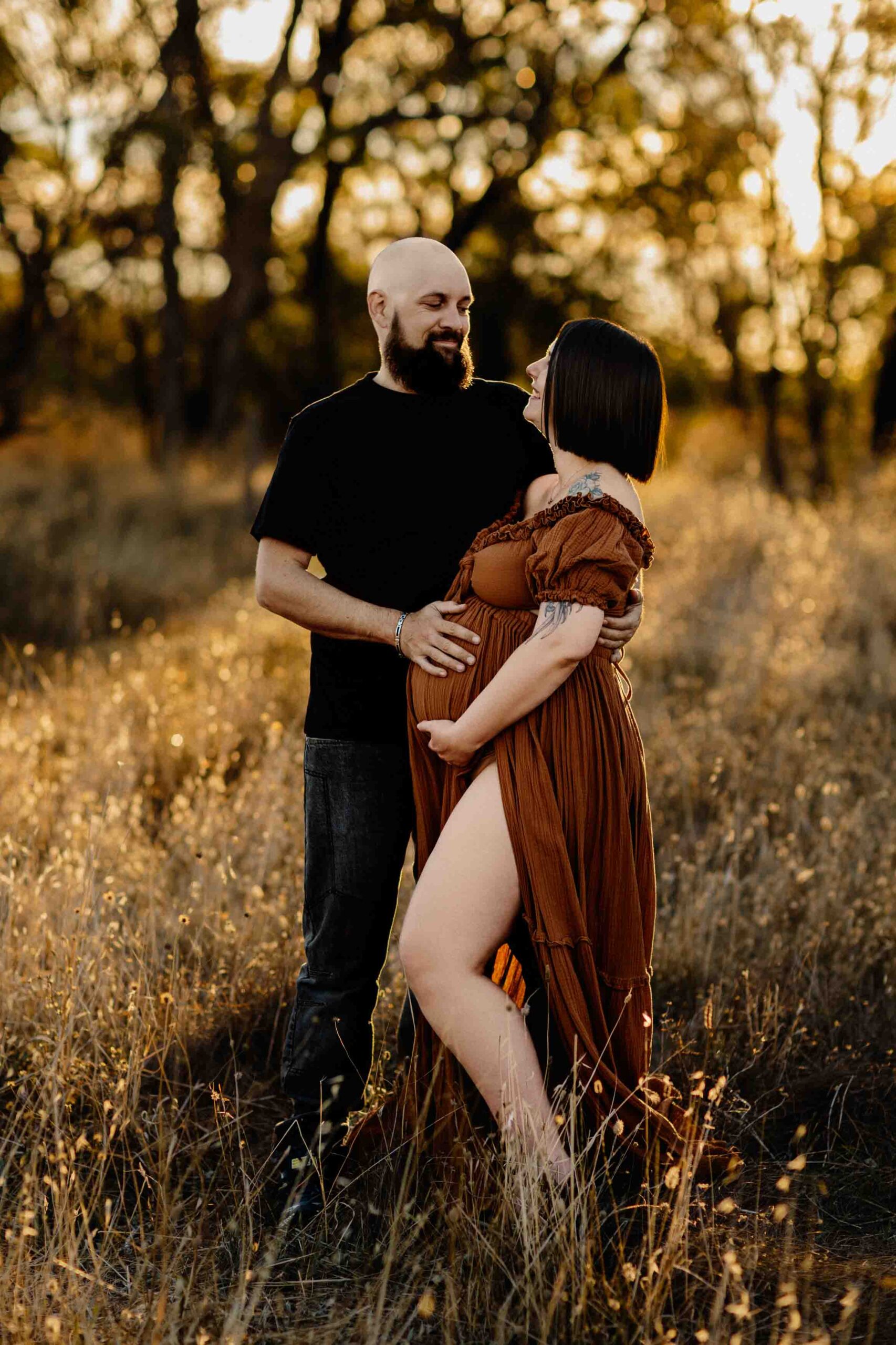 A couple from Adelaide cuddling with their hands on the woman's pregnant belly.