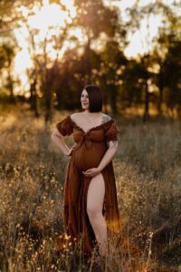 A mum from Adelaide looking to the side wearing a rust dress.