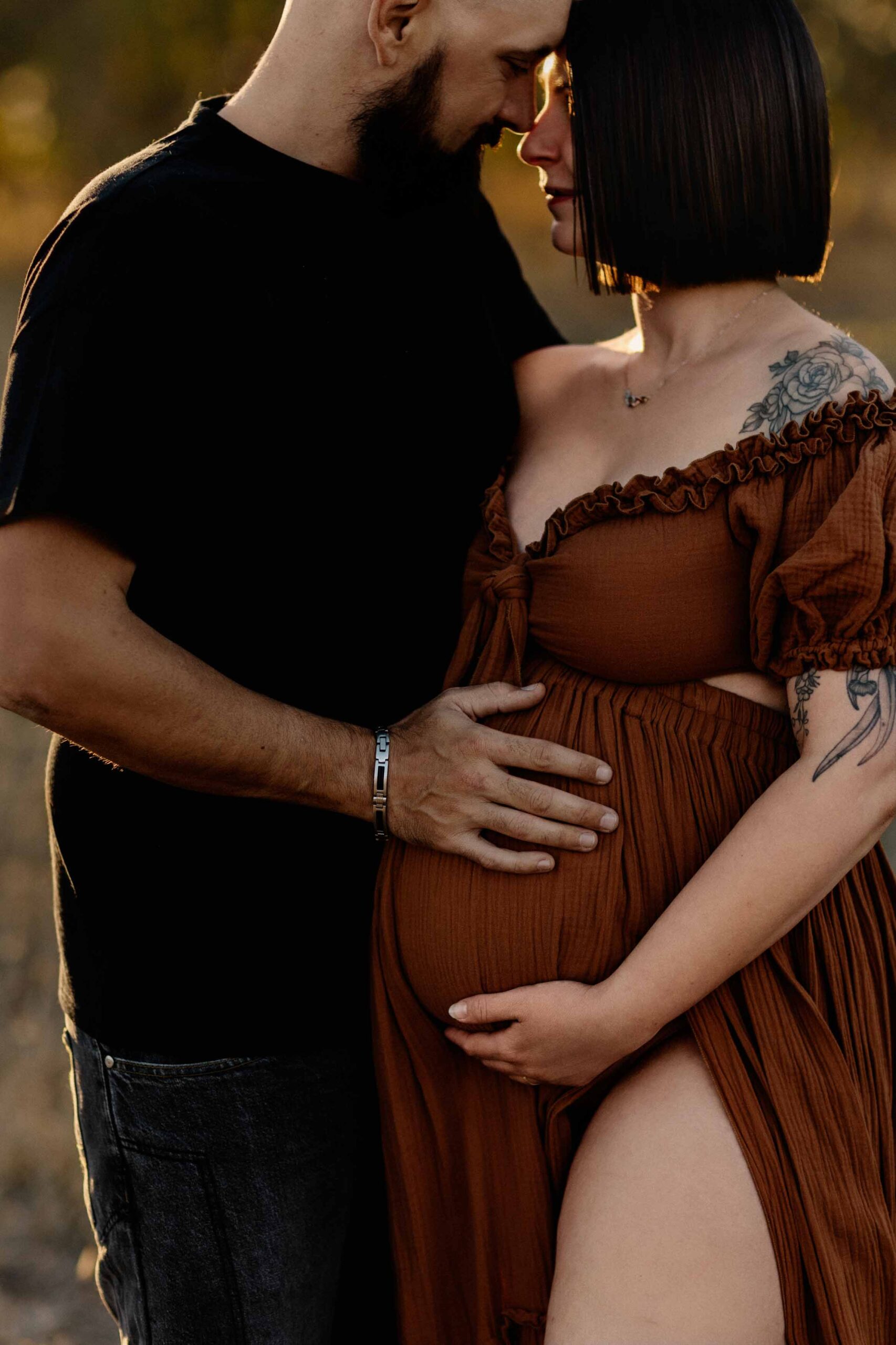 A couple from Adelaide cuddling a pregnant belly.