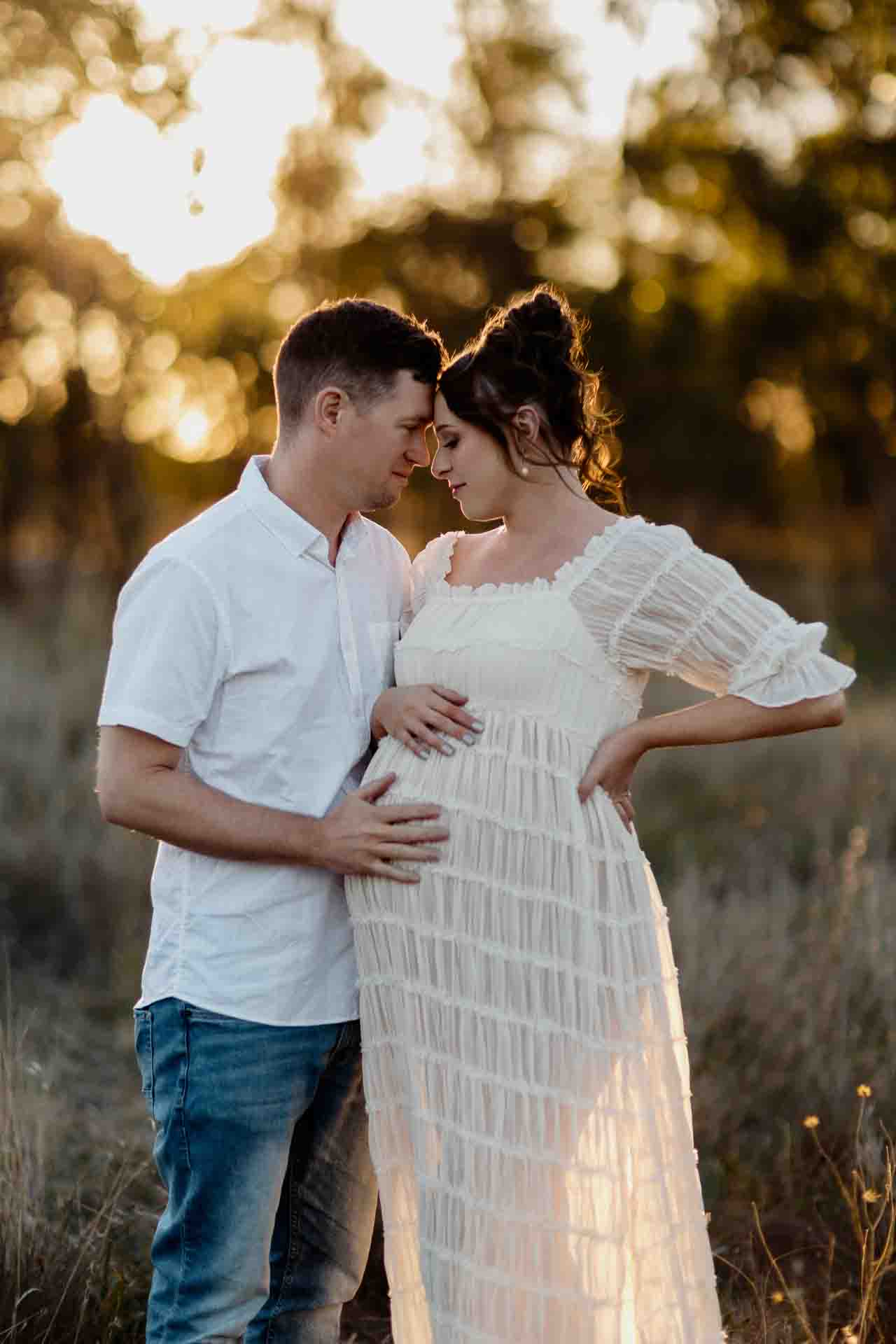 A pregnant mother and her partner touching foreheads at a maternity session in Adelaide.