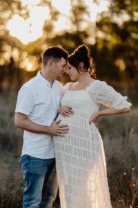 A pregnant mother and her partner cuddling at a maternity session in Adelaide.