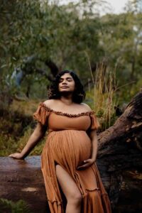 A pregnant mother wearing a rust dress at a maternity session in the Adelaide Hills.