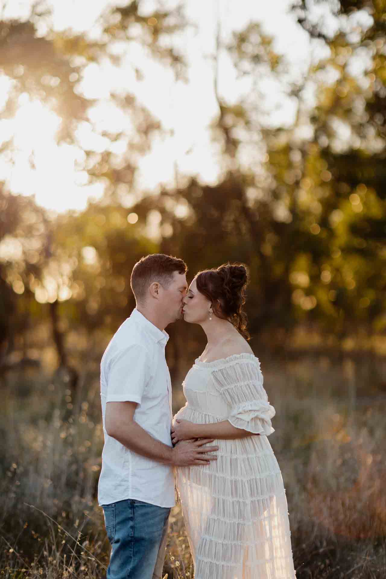 A pregnant mother and her partner kissing at a maternity session in Adelaide.