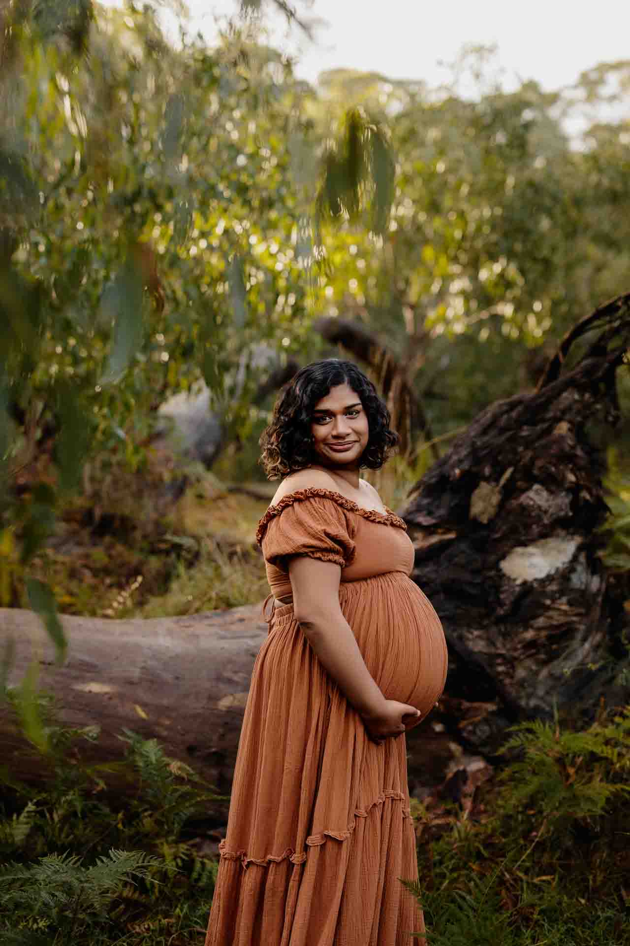 A pregnant mother wearing a rust dress at a maternity photography session in the Adelaide Hills.