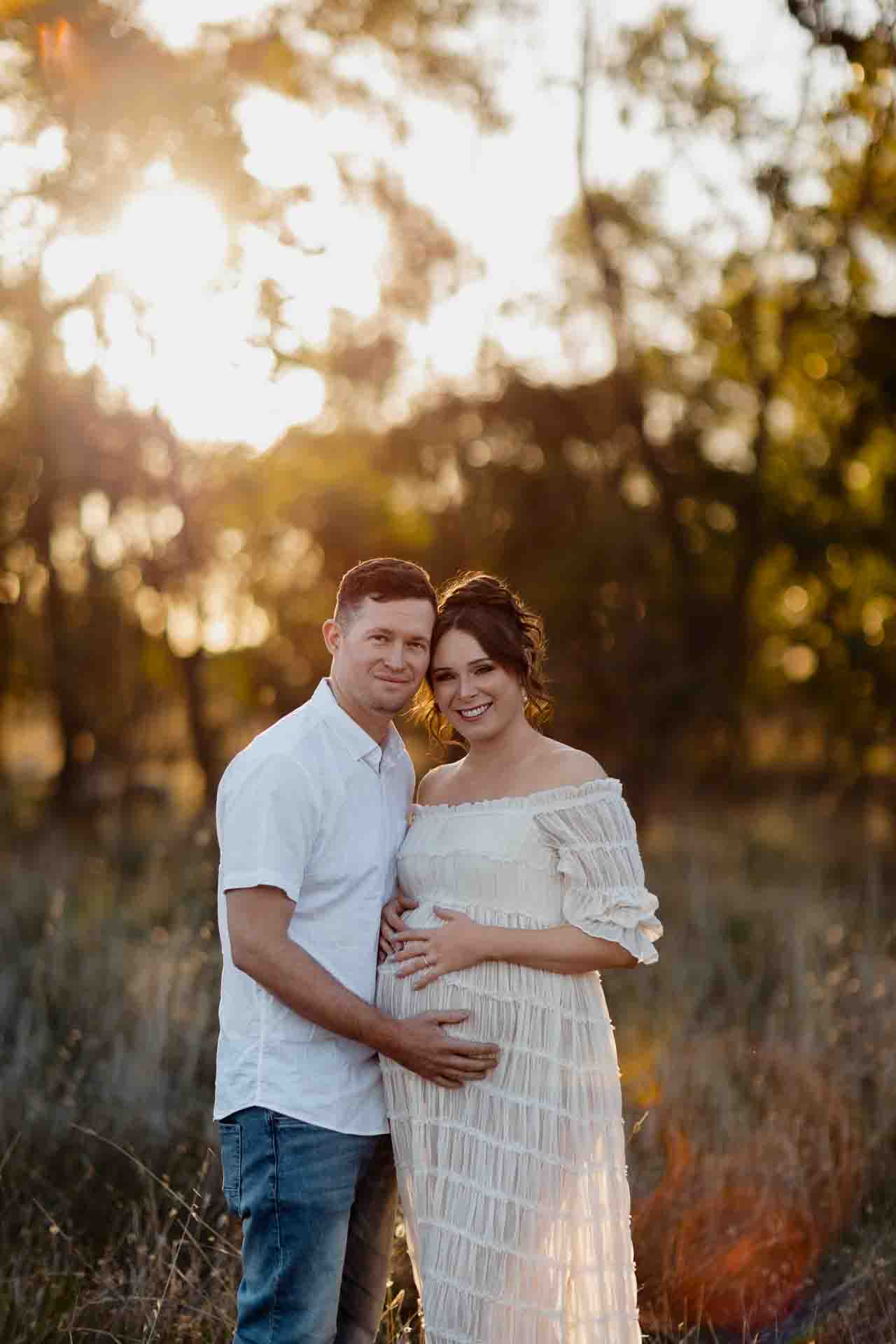 A pregnant mother and her partner smiling at a maternity session in Adelaide.