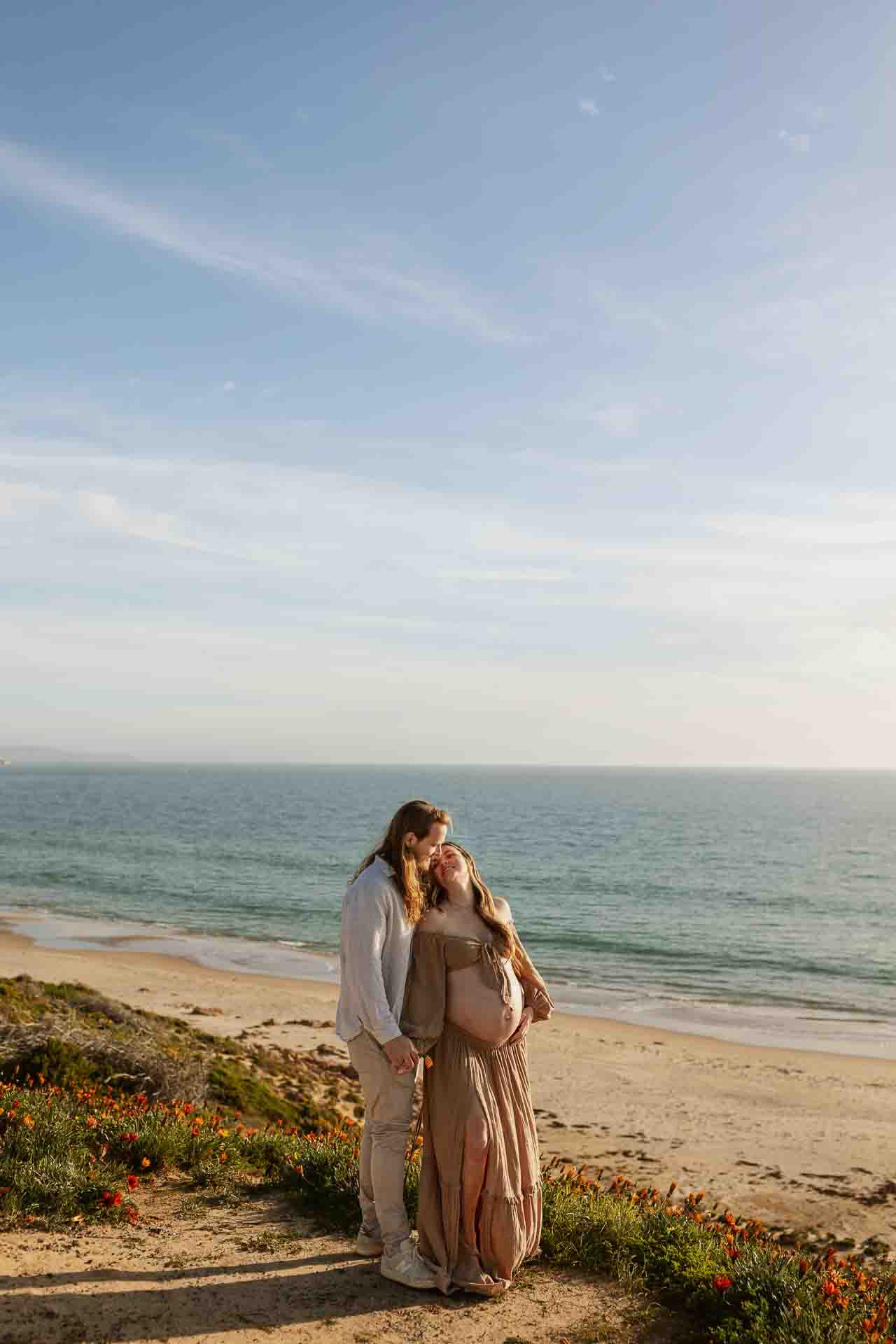 Adelaide couple together during their coastal maternity session overlooking the beach
